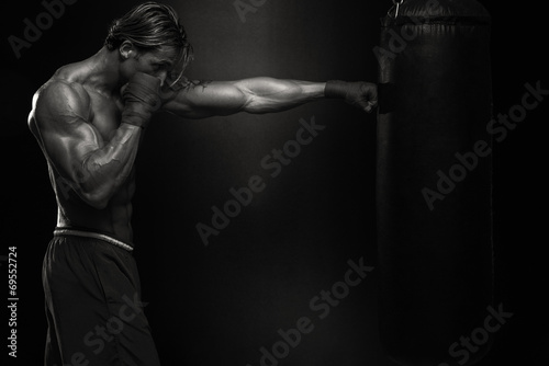 MMA Fighter Practicing With Boxing Bag © Jale Ibrak