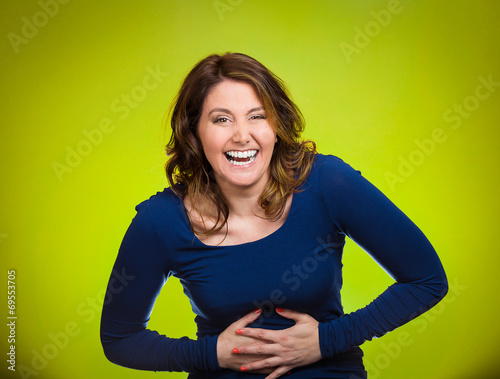 Laughing woman hearing good news joke on green background  photo