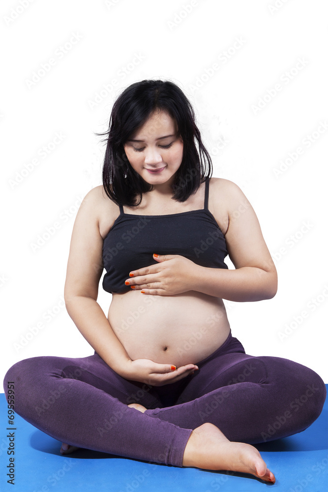 Pregnant woman sitting on mattress Pregnant woman sitting on mattress