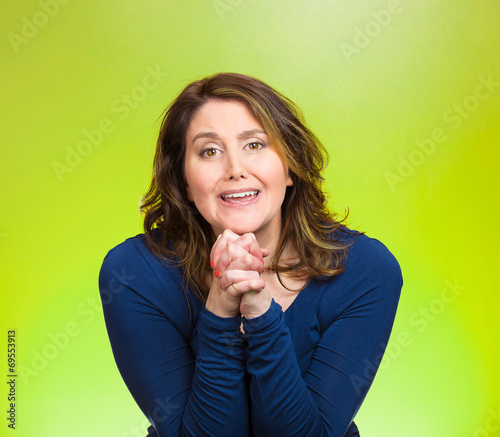 Woman gesturing with clasped hands, pretty please begging  