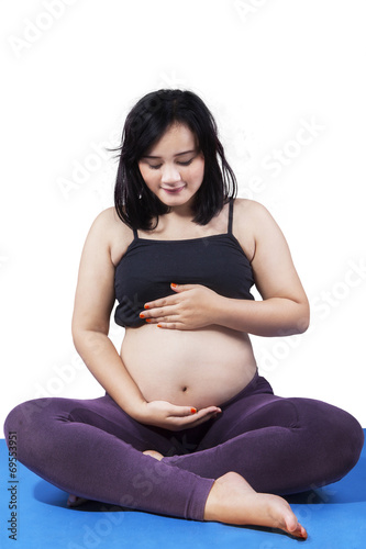 Pregnant woman sitting on mattress