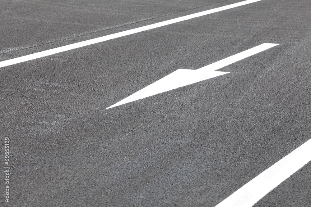 White traffic arrow signage on an asphalt road White traffic arrow signage on an asphalt road