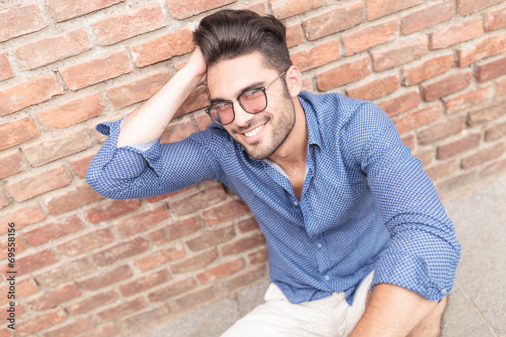 man with glasses fixing his hair while seated man with glasses fixing his hair while seated