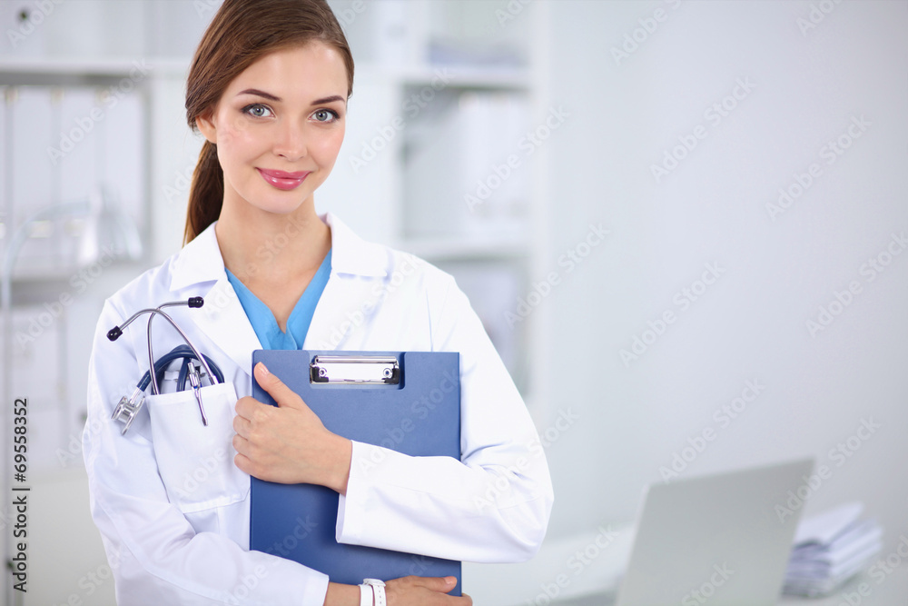 Smiling female doctor with a folder in uniform standing at hosp