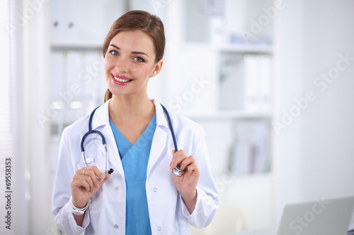 Portrait of happy successful young female doctor holding a stet