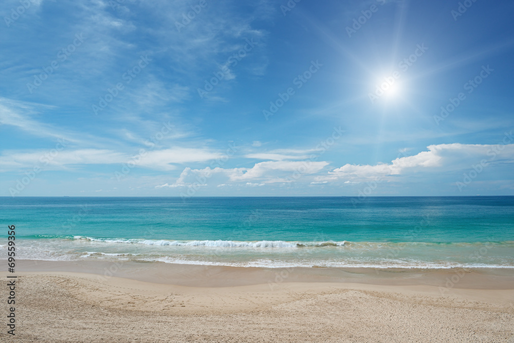 Naklejka premium Sandy beach and sun in blue sky
