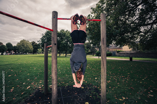 Woman dangling from pullup bars