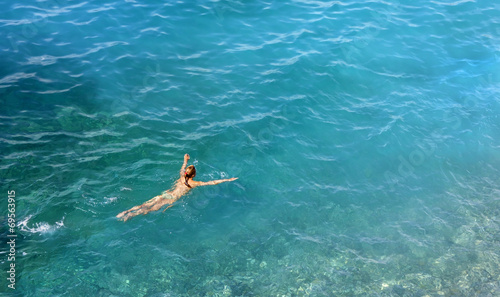 Young Woman Swimming in a Turquoise Water