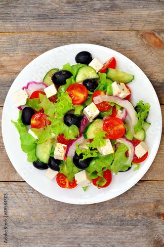 Greek salad (top view) on a wooden table