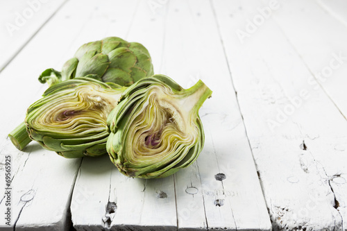 Artichoke cut in half on white with copy space