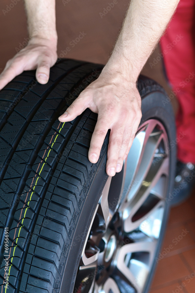 Obraz premium Reifenwechsel in einer KFZ Werkstatt // Tire change by mechanic