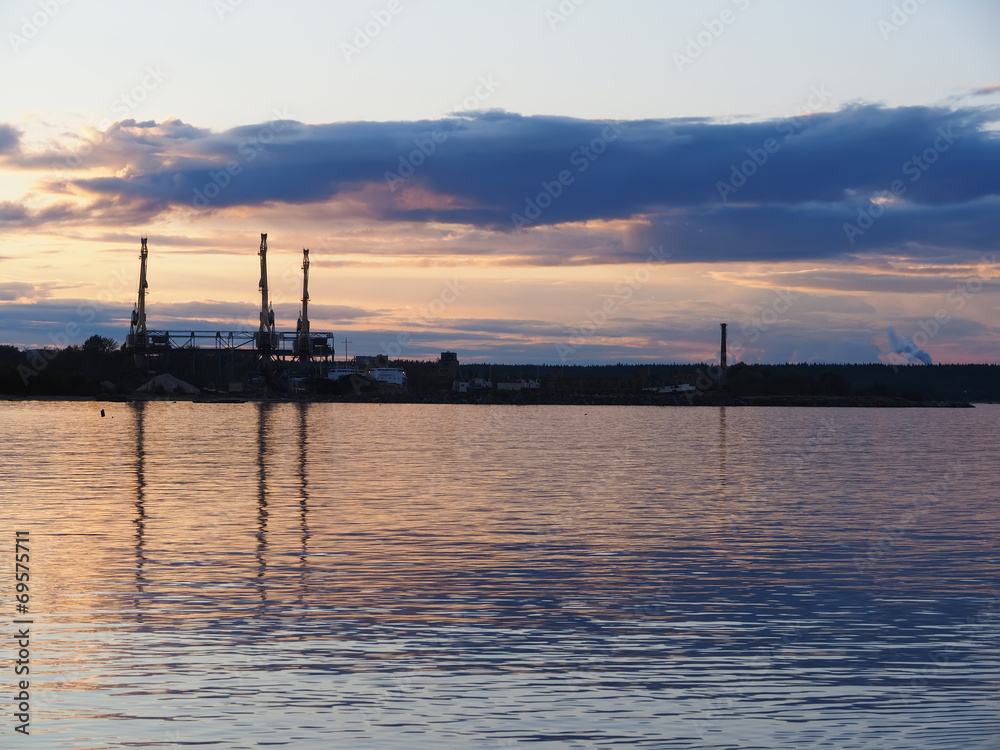 an industrial city on the shore of lake at sunset
