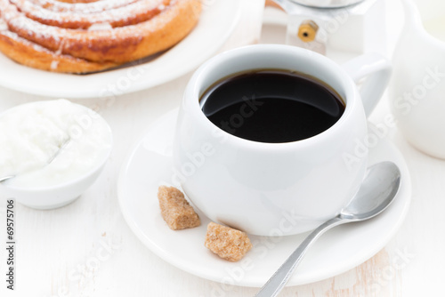 black coffee, sweet bun and cream for breakfast
