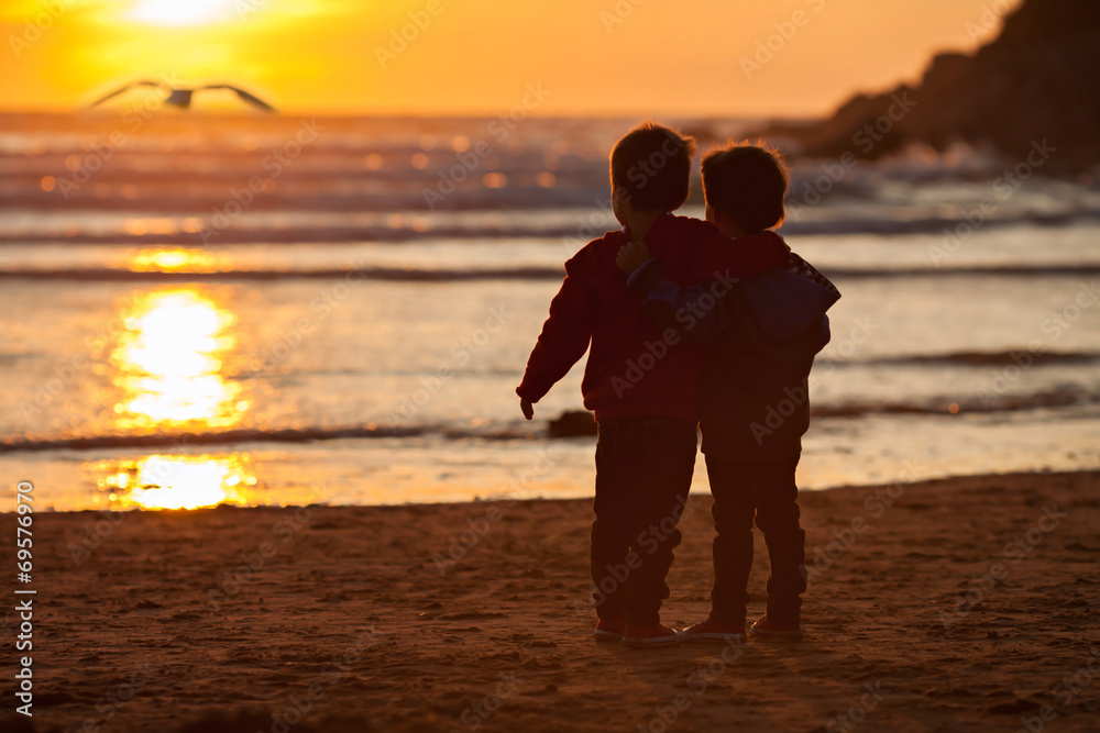 Fototapeta premium Beautiful picture of two boys on the beach at sunset