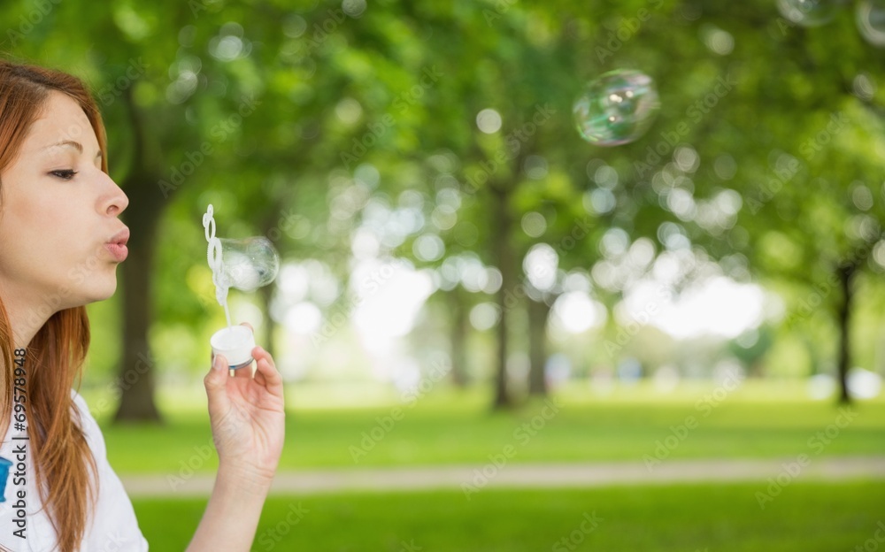 Pretty redhead blowing bubbles in the park Pretty redhead blowing bubbles in the park