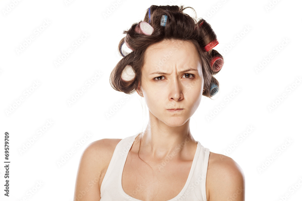 angry and scowling woman without makeup and with hair curlers angry and scowling woman without makeup and with hair curlers