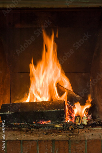 Warm flames burning some wood in a rustic fireplace