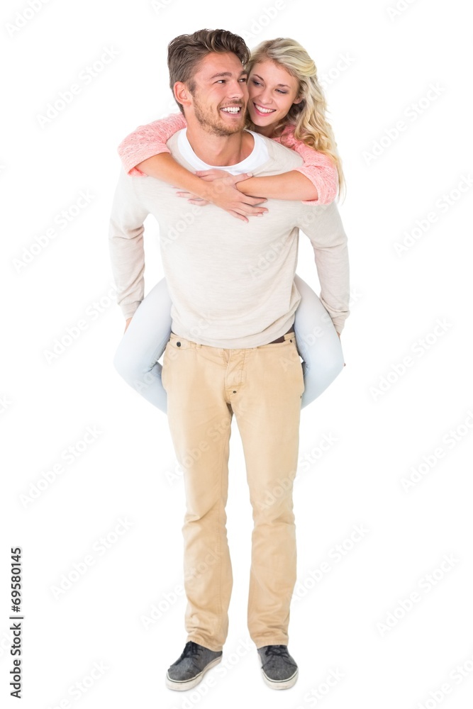 Handsome man giving piggy back to his girlfriend Handsome man giving piggy back to his girlfriend