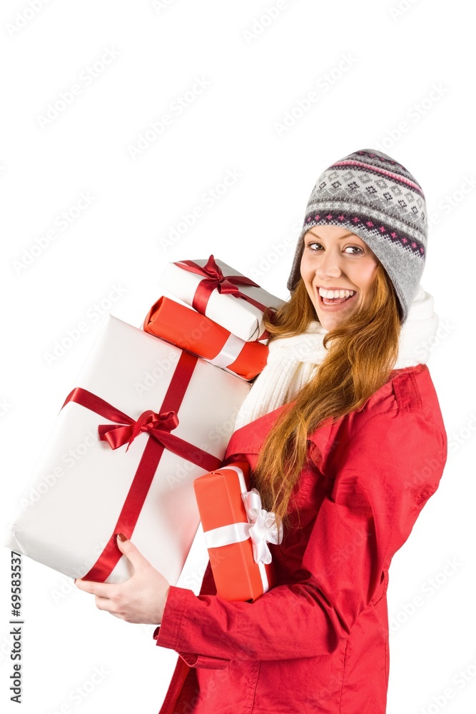 Pretty redhead in warm clothing holding gifts