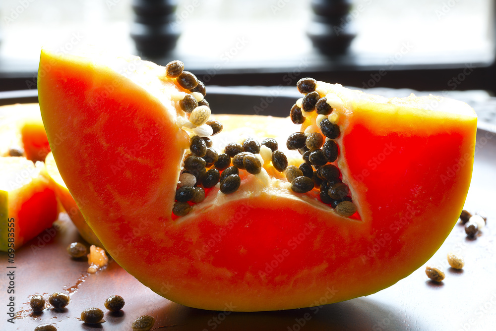 Papaya slices on a wooden tray Papaya slices on a wooden tray
