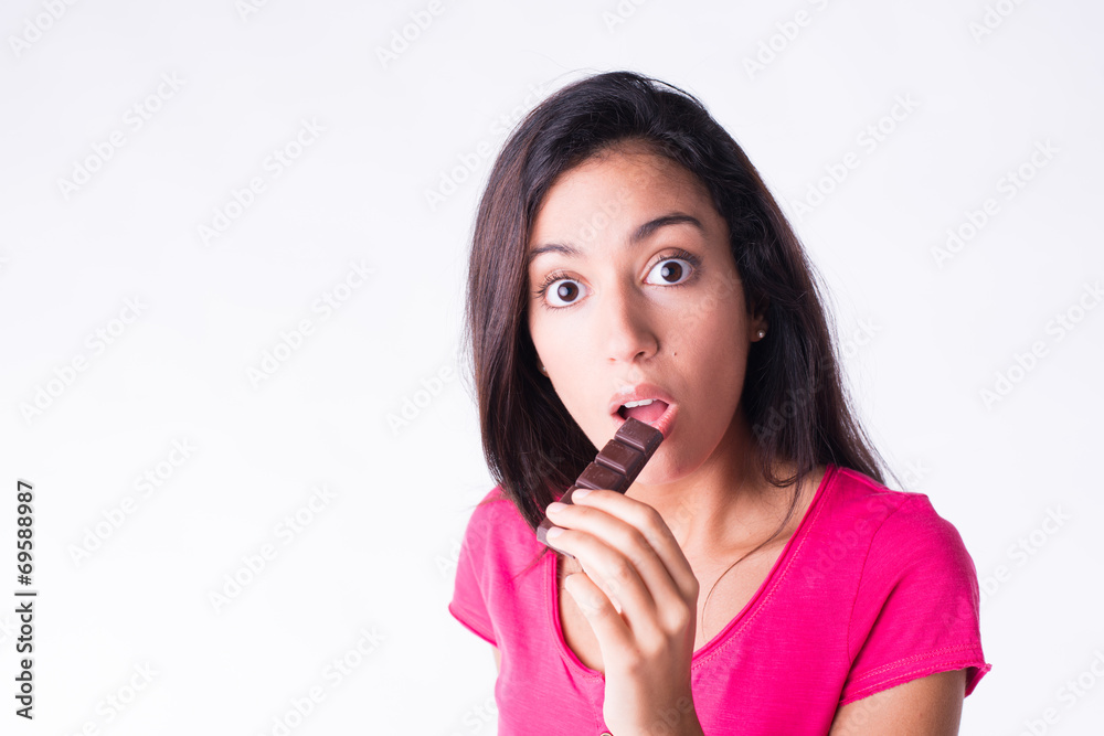 Fototapeta premium beautiful young woman eating chocolate guilty attitude