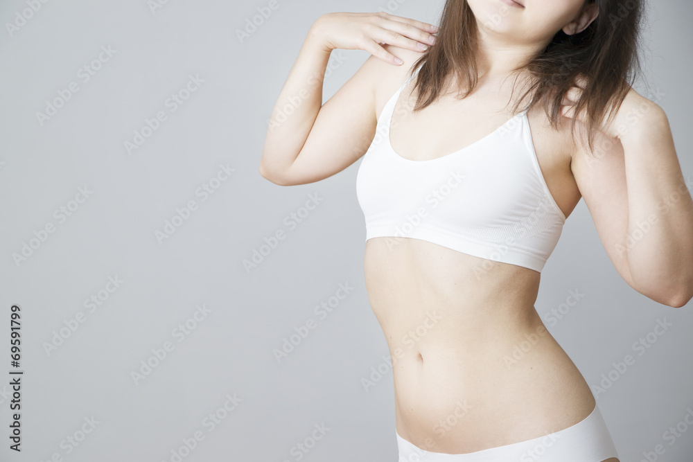 Young woman in white lingerie on a gray background Young woman in white lingerie on a gray background