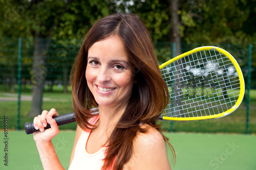 beautiful brunette holding a squash racket.