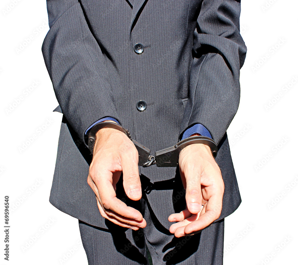Man in black suit in handcuffs on his hands isolated