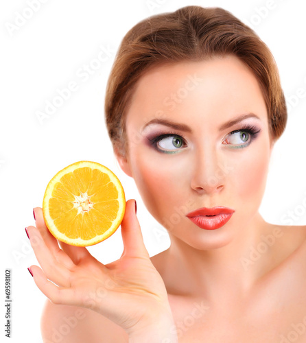 Beautiful young woman with bright make-up, holding orange,