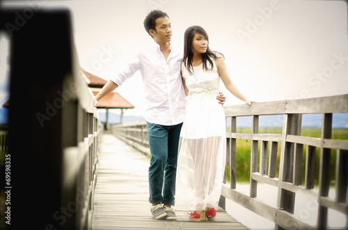 Beautiful married couple on the wooden bridge.