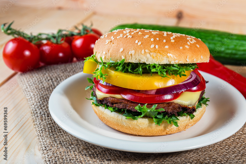 homemade hamburger with fresh vegetables on cutting board homemade hamburger with fresh vegetables on cutting board