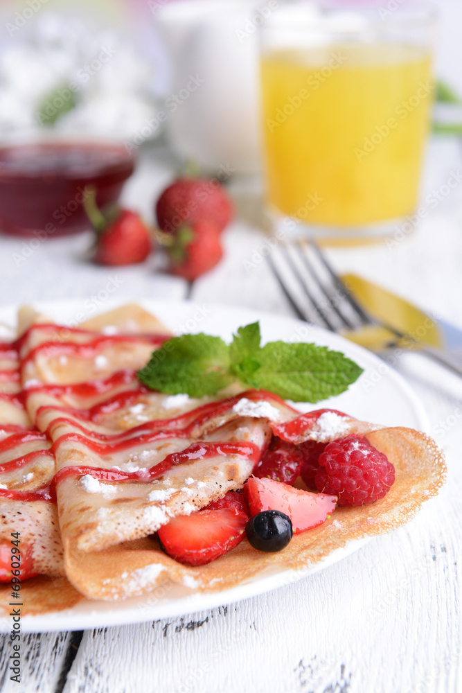 Delicious pancakes with berries on table close-up