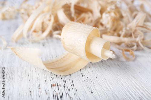 Wood shavings on white wooden background closeup