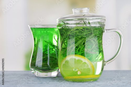 Estragon drink on wooden table on bright background