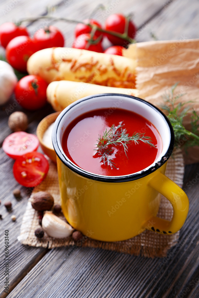 Homemade tomato juice in color mug, bread sticks, spices and Homemade tomato juice in color mug, bread sticks, spices and