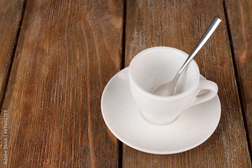 Empty cup with tea spoon on wooden background Empty cup with tea spoon on wooden background