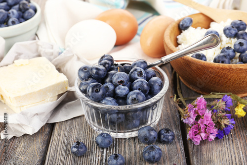 Fresh blueberries and milk products on wooden table