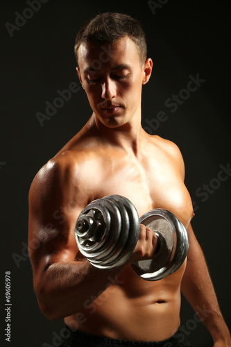 Handsome young muscular sportsman execute exercise with