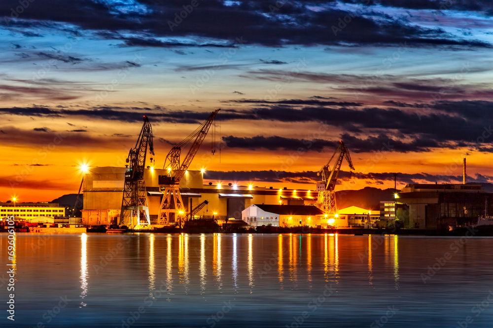 Sunset over an industry harbor with cranes in Stavanger, Norway.