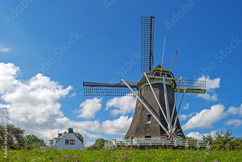 Windmill on a dike under a blue sky