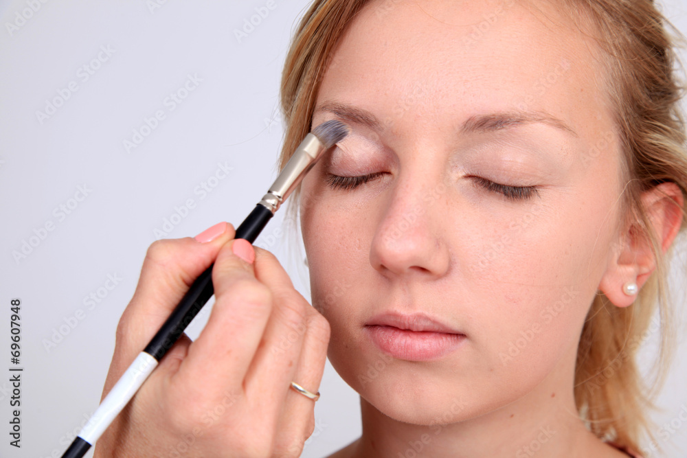 Makeup artist applying makeup to model