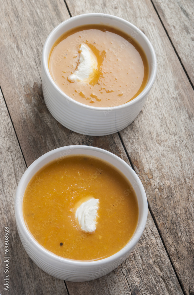 two bowls of squash soup on wooden table two bowls of squash soup on wooden table