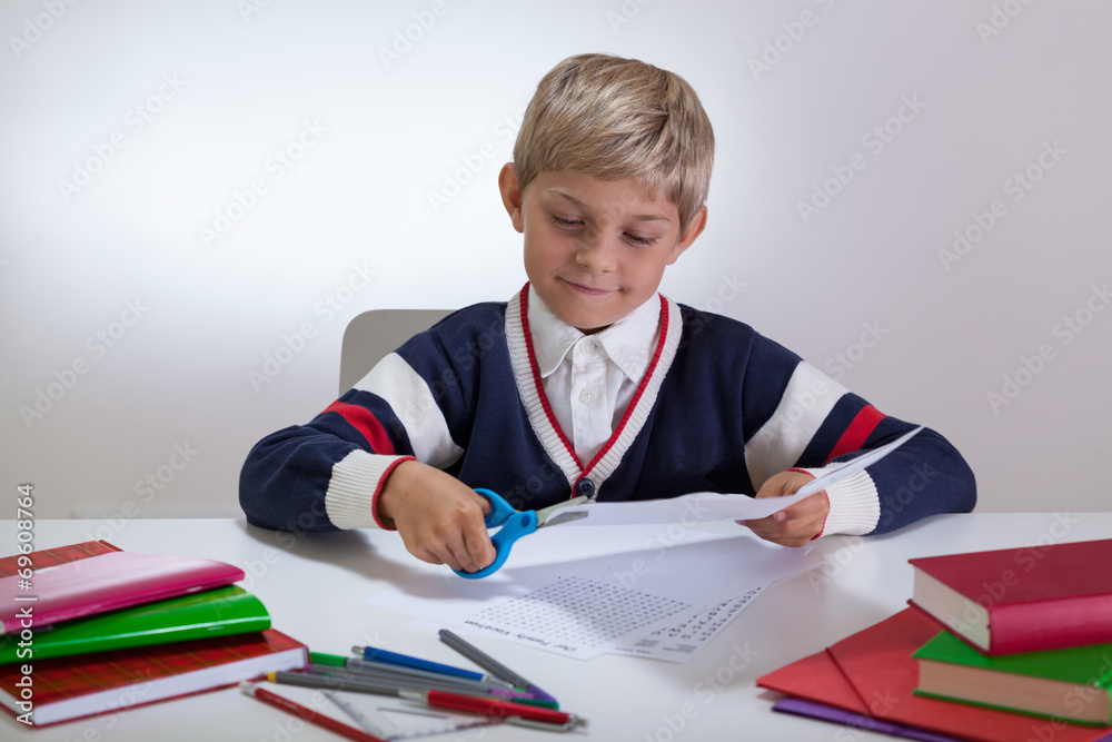 Boy using scissors on the desk Boy using scissors on the desk