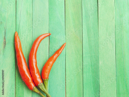 Red hot chili peppers on green wooden old retro vintage style