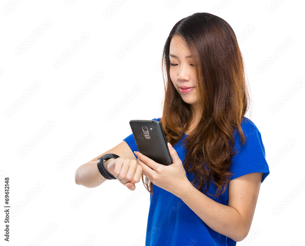 Woman synchronize data from wearable watch with mobile phone Woman synchronize data from wearable watch with mobile phone