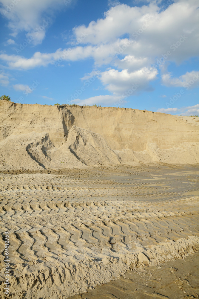 Sand quarry, heap of sand with tire tracks, landscape