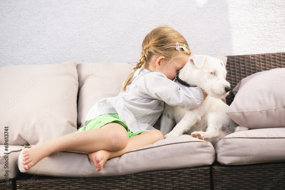 Junges Mädchen umarmt ihren Hund auf Sofa Junges Mädchen umarmt ihren Hund auf Sofa