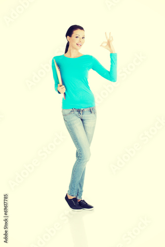 beautiful casual woman holding  files and showing OK.