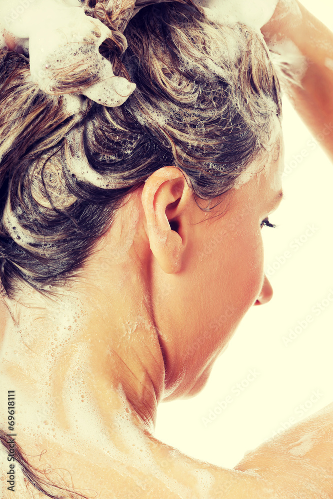 Naklejka premium Beautiful woman taking a shower and shampooing her hair.
