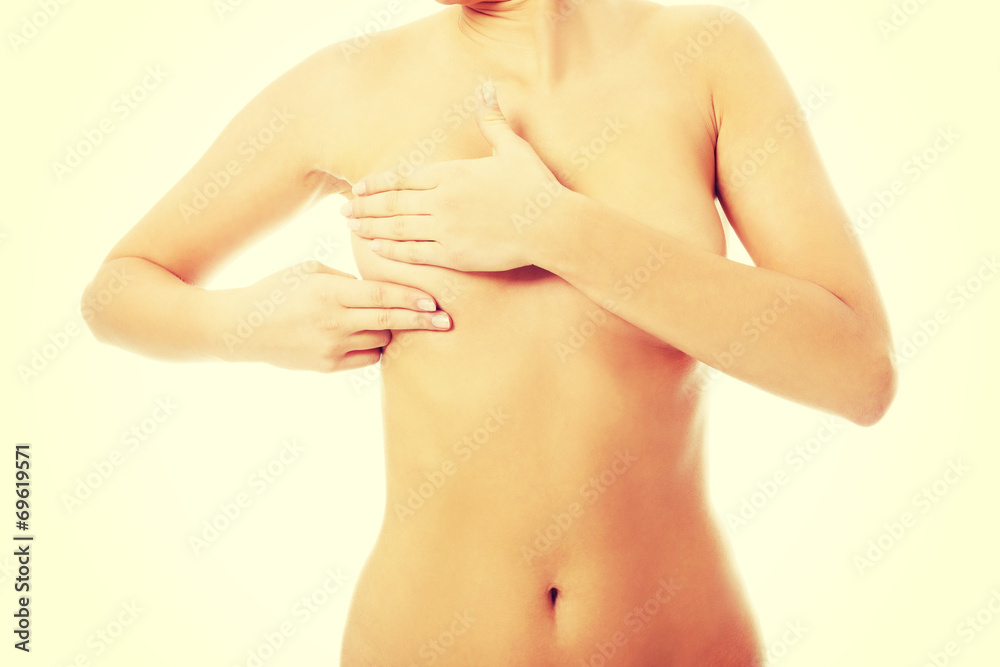 Fototapeta premium Young topless woman is examinning her breasts.